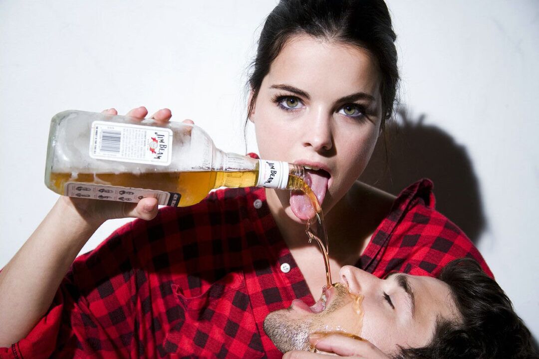 Une fille verse de l'alcool sur un homme avant de faire l'amour